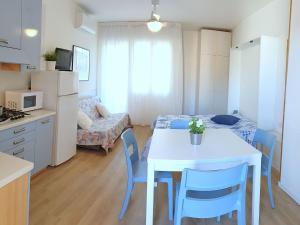 eine Küche und ein Wohnzimmer mit einem Tisch und Stühlen in der Unterkunft Apartment in Bibione with balcony in Bibione