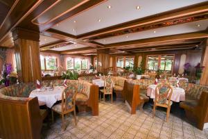 a restaurant with tables and chairs in a room at Golf-Tennis-Wellnesshotel Mori in Sankt Kanzian