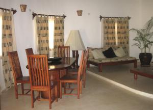 a living room with a table and chairs and a couch at Watamu Villa With Service Personnel in Watamu