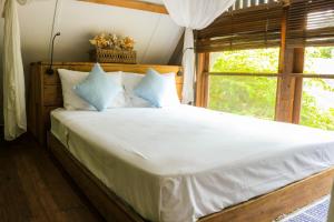 1 dormitorio con 1 cama grande y ventana en Chanteak Bali - Stone House 2, en Jimbaran