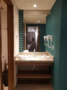 a bathroom with a sink and a mirror at APARTAMENTO OLIMPIA SOLAR DAS AGUAS in Olímpia