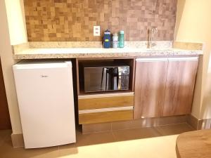 a small kitchen with a sink and a refrigerator at APARTAMENTO OLIMPIA SOLAR DAS AGUAS in Olímpia