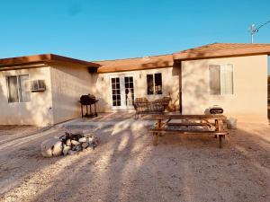una casa con un tavolo da picnic di fronte di Casa Agave: Comfy Joshua Tree Cottage With Free Breakfast Bar a Joshua Tree