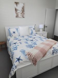 een slaapkamer met een bed met blauwe en witte lakens bij Hidden Gem Holiday Let in South Mission Beach