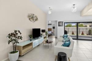a living room with a couch and a tv at Lowtide Five Bedroom 22 in Torquay