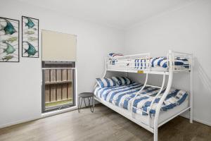 a bedroom with two bunk beds and a window at Lowtide Five Bedroom 22 in Torquay