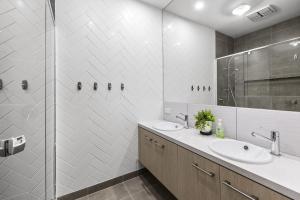 a white bathroom with a sink and a shower at Lowtide Five Bedroom 22 in Torquay +7 photos