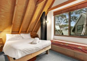 a bed in a room with a large window at Coolong in Dinner Plain