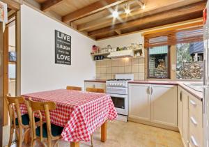 a kitchen with a table with a red and white table cloth at Coolong in Dinner Plain +2 photos