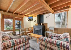 a living room with couches and a tv and a table at Coolong in Dinner Plain