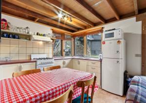 a kitchen with a table and a white refrigerator at Coolong in Dinner Plain