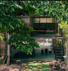 a tree house with a deck and a bench at Green House Tambopata in Puerto Maldonado