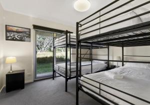 two bunk beds in a bedroom with a window at Crooked 2 in Dinner Plain