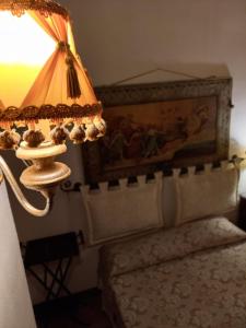 een lamp in een slaapkamer met een bed en een schilderij bij Suite alla Cattedrale in Palermo