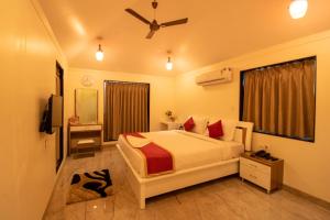 a bedroom with a bed and a ceiling fan at Casa Majestic Resort and SPA in Panchgani