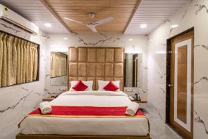 a bedroom with a large bed with red pillows at Casa Majestic Resort and SPA in Panchgani