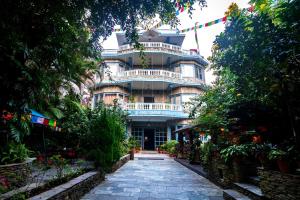 
a large building with a balcony and a walkway at Hotel Silver Oaks Inn in Pokhara
