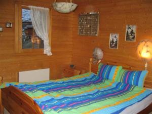 グリメンツにあるChalet Veranoの木製の部屋にベッド1台が備わるベッドルーム1室があります。