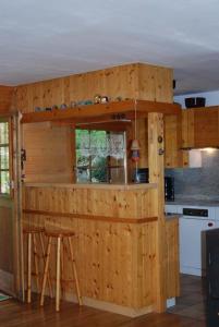 eine Holzbar in einer Küche mit zwei Hockern in der Unterkunft Chalet Verano in Grimentz