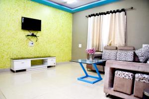 a living room with a tv and a couch and a table at DV INNS FARMVILLA - Besides Strawberry Farms in Mahabaleshwar