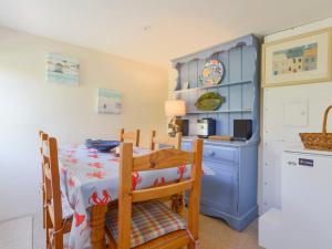 a dining room with a table and a kitchen at Yew Tree Cottage in Dartmouth