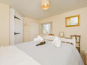 a bedroom with a white bed with towels on it at Yew Tree Cottage in Dartmouth