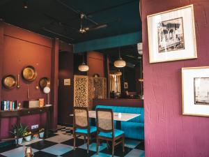 a dining room with a pink wall and a table and chairs at Ekaa Villa near Taj Mahal in Agra
