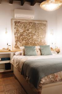- une chambre avec un lit orné d'une grande peinture murale dans l'établissement Corduba Suite, à Cordoue