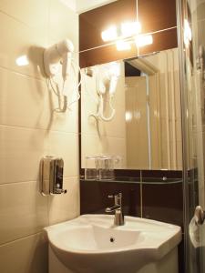 
a bathroom with a sink, mirror, and toilet at Budapest Suites in Budapest
