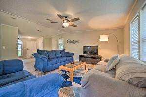 een woonkamer met blauwe banken en een flatscreen-tv bij Updated Lakeland Home and Fire Pit on 10 Acres! in Lakeland
