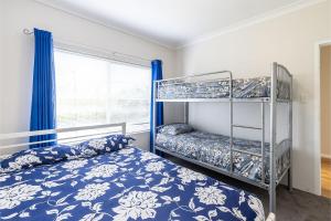 a bedroom with two bunk beds and a window at 4 'Adriana', 83 Ronald Avenue - open plan living with backyard in Shoal Bay