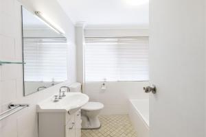 a white bathroom with a sink and a toilet at Adriana 4 open plan living with backyard in Shoal Bay