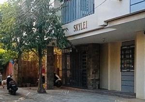 a shop with a tree in front of a building at Skyleigh Apartelle by RedDoorz in Iloilo City