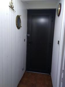 a black door in a hallway with a tile floor at Résidence naturiste Aphrodite appartement 940 in Leucate