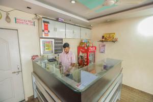 a man standing behind a counter in a store at Hotel Sai Niwas in Lonavala