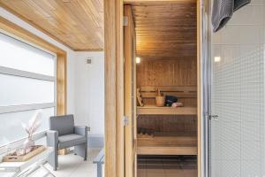 a bathroom with a shower and a chair in a room at Villa Du bonheur met Sauna en Jacuzzi in Somme-Leuze