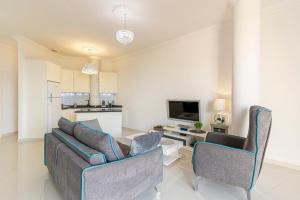 un soggiorno con due sedie, un divano e un tavolo di Apartment Andrea ad Adeje