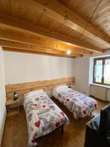 2 Betten in einem Zimmer mit Holzdecken in der Unterkunft CABALDO in Ranica