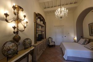 Casa Raiola Ercolano Luxury Rooms & Spa في إيركولانو: غرفة نوم بسرير وثريا