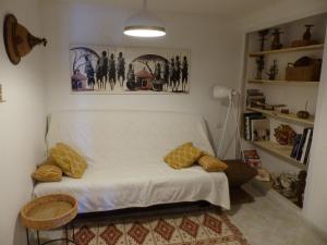 een woonkamer met een witte bank met kussens erop bij L'antre sol in Sète