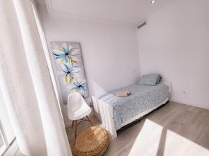 niewielka sypialnia z łóżkiem i krzesłem w obiekcie Stylish 3 Bedroom Penthouse in Marbella Centre with Large Pool close to the Beach w Marbelli +14 zdjęć