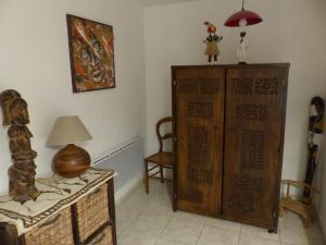 een kamer met een houten kast en een tafel met een lamp bij L'antre sol in Sète