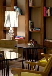 a living room with a table and chairs and a lamp at Witt Istanbul Suites in Istanbul