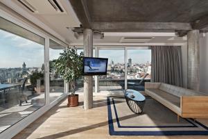 a living room with a couch and a flat screen tv at Witt Istanbul Suites in Istanbul