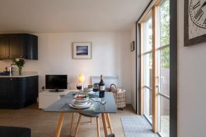 a living room with a table and a kitchen at Boat Lake in Thorpeness
