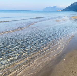 una playa de arena con un cuerpo de agua en Sebastian's - Agios Gordios Beach en Agios Gordios