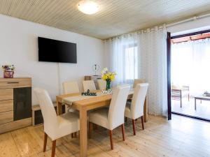 a dining room with a wooden table and white chairs at Apartments Nada in Poreč
