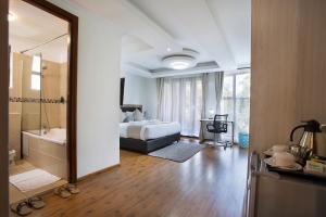 a bedroom with a bed and a bathroom with a mirror at Edmor Residences Riverside in Nairobi
