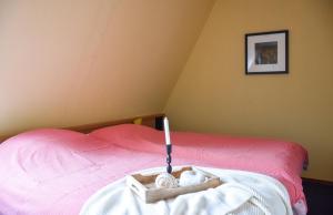 een slaapkamer met een bed met een kaars in een dienblad bij Wyn 72 in Hollum