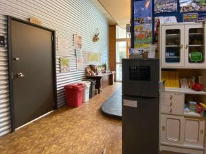 um quarto com uma porta e um frigorífico numa sala de aula em Forte em Hachijo